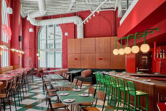 Unc's dining room lined with tables and green chairs
